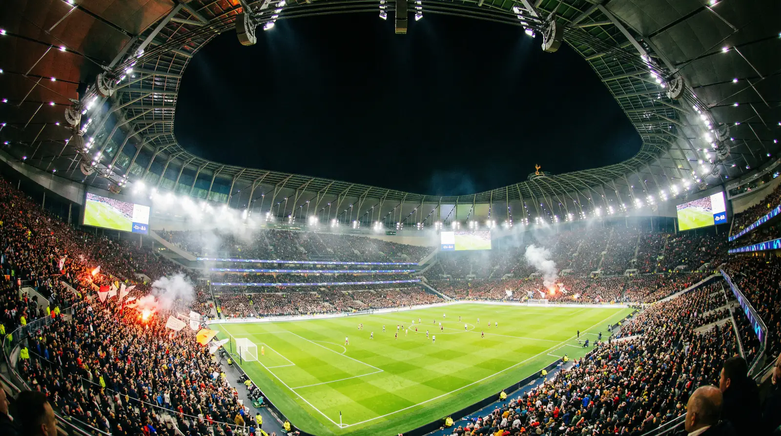 Jalkapallostadion iltavalaistuksessa täynnä katsojia